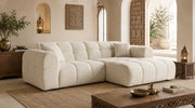 A BEIGE BOUCLE SECTIONAL WITH ROUNDED ARMS , DEEP CUSHIONED SEATS AND WIDE CHAISE SEATING. MEASUREMENT 240X153X71CM