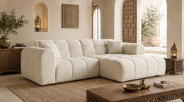 A BEIGE BOUCLE SECTIONAL WITH ROUNDED ARMS , DEEP CUSHIONED SEATS AND WIDE CHAISE SEATING. MEASUREMENT 240X153X71CM