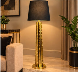 A LUXURY GOLD FLOOR LAMP WITH A BLACK FABRIC SHADE AND A DISTINCTIVE STUDDED METALLIC COLUMN.  MEASUREMENT 40X40X156CM