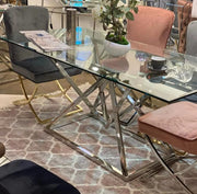 PYRAMIDE DINING TABLE FEATURES A SILVER BASE WITH A TRANSPARENT GLASS TOP COMBINING MODREN GEOMETRIC DESIGN AND ELEGANCE 150X90X75