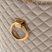 QUILTED STUDDED RING CHAIR IN BEIGE VELVET AND GOLD FINISH.