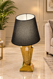 A LUXURY TABLE LAMP WITH A BALCK TEXTURED LAMPSHADE AND BLACK AND GOLD FEETS. MEASUREMENT 90CM